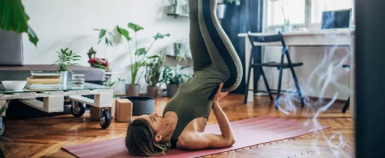 Woman holding a shoulder stand yoga pose at home